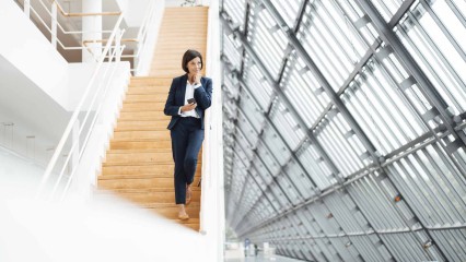 Femme dans les escaliers d'un immeuble moderne