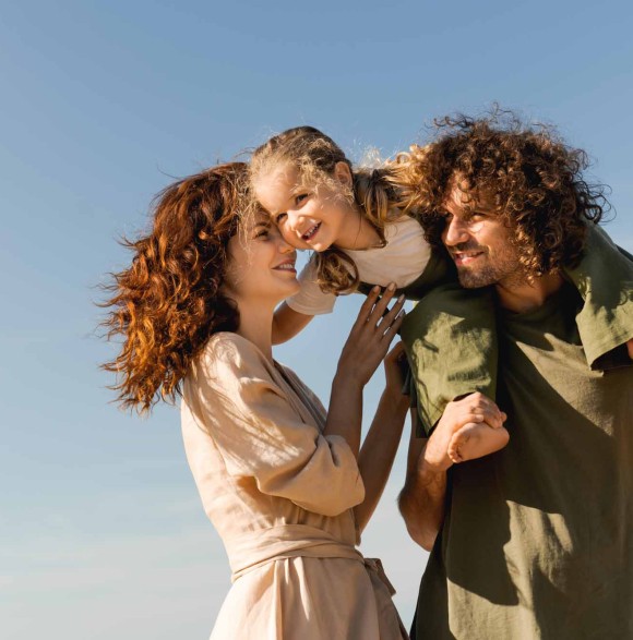 Un couple et leur enfant dehors, complices